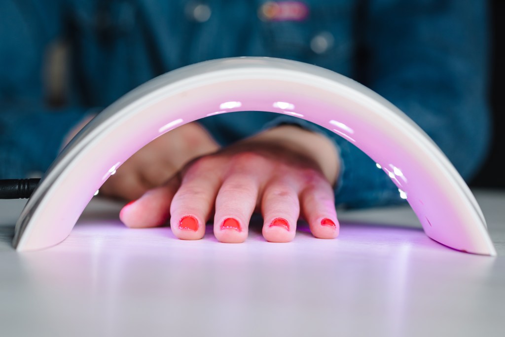 Lámpara UV brillante para secar uñas pintadas de rojo.