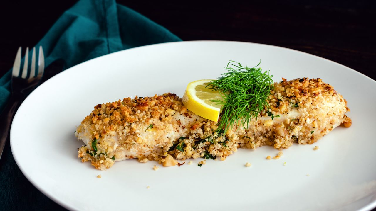 Filete de pescado blanco a la plancha aderezado con eneldo fresco y una rodaja de limón