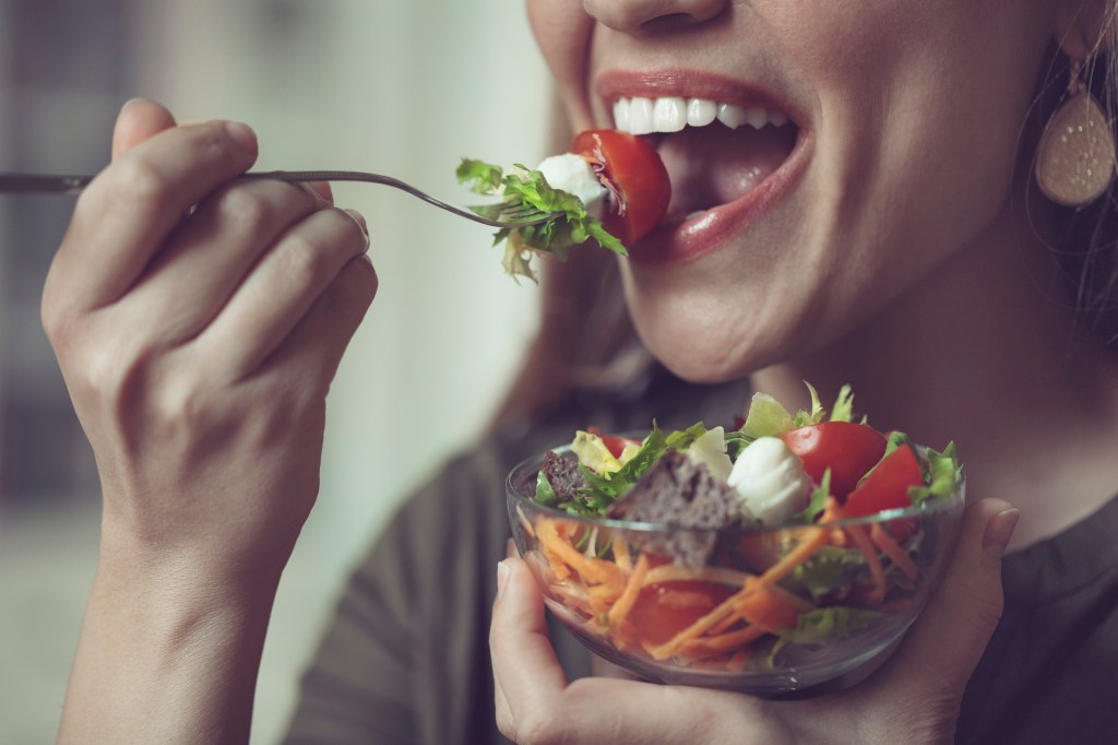 una mujer que come ensalada