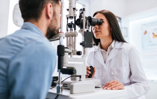 una oftalmóloga examina la vista de un joven en una clínica moderna.