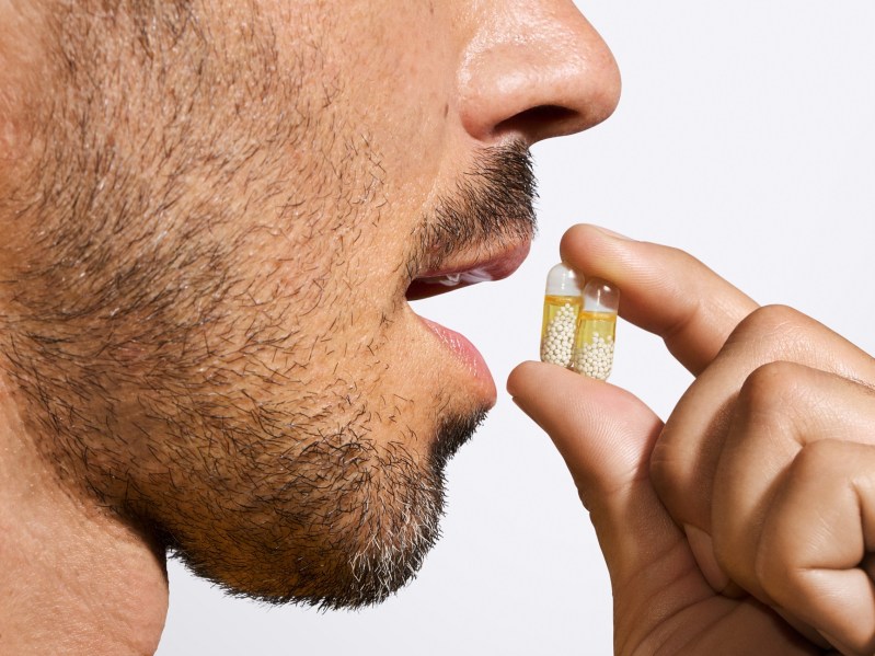 Un hombre tomando una cápsula multivitamínica Ritual Essential