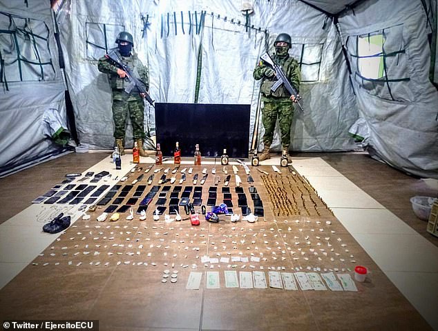 Soldados ecuatorianos exhiben botellas de alcohol, teléfonos celulares, relojes y drogas incautadas en una prisión de la central provincia de Cotopaxi.
