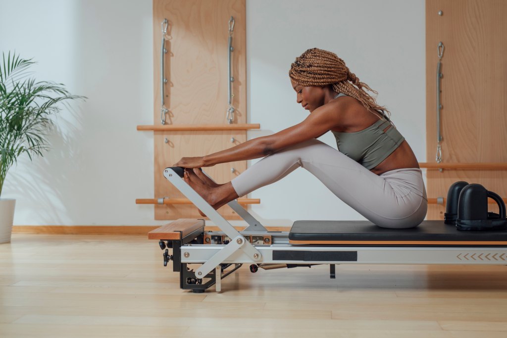 una mujer haciendo ejercicios de pilates en el reformador para bajar de peso