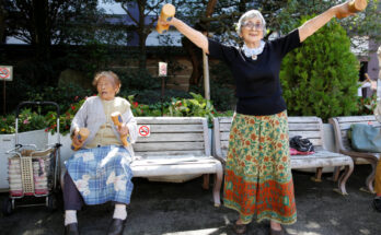Natsu Naruse, 100 year-old, and other partcipants exercise with wooden dumbbells during a health promotion event to mark J...
