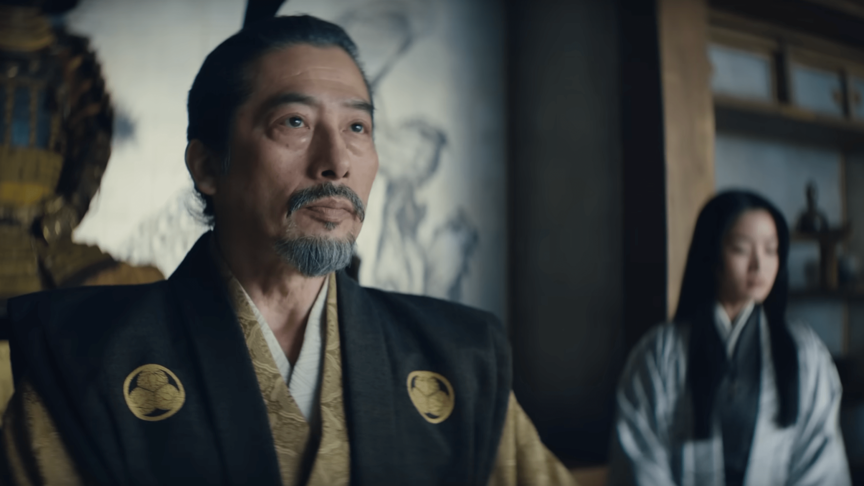 La pantalla de la tarde describiendo a Hiroyuki Sanda como el rey Toranaga está sentado en su trono, mirando en la pantalla