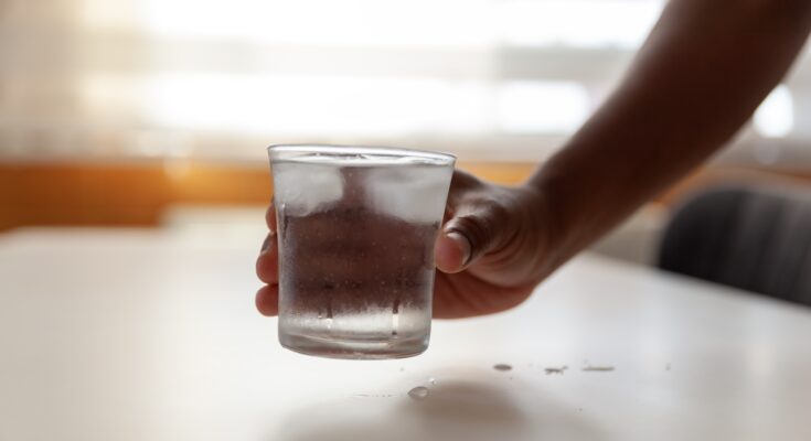 a hand holding a glass of water
