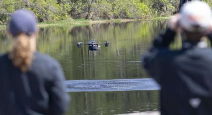 a drone flying low over a body of water