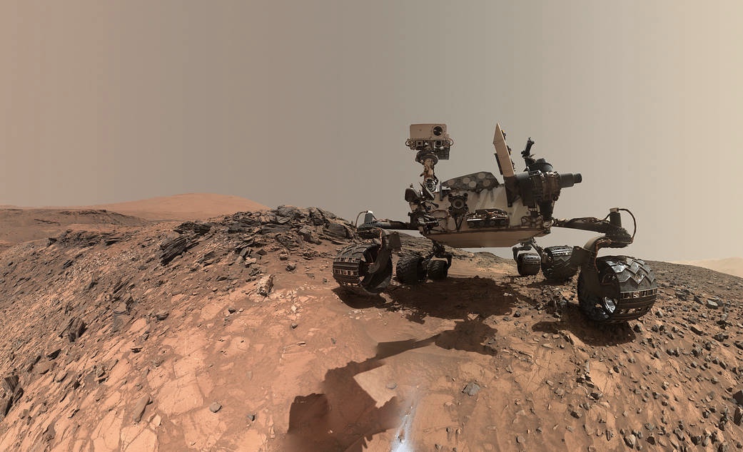Rover de cuatro ruedas en un planeta rojo naranja