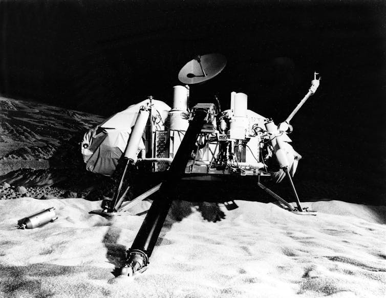 Menor, bajo en la nave espacial molida con disco de antena que apuntaba hacia arriba, descansando sobre piedras.