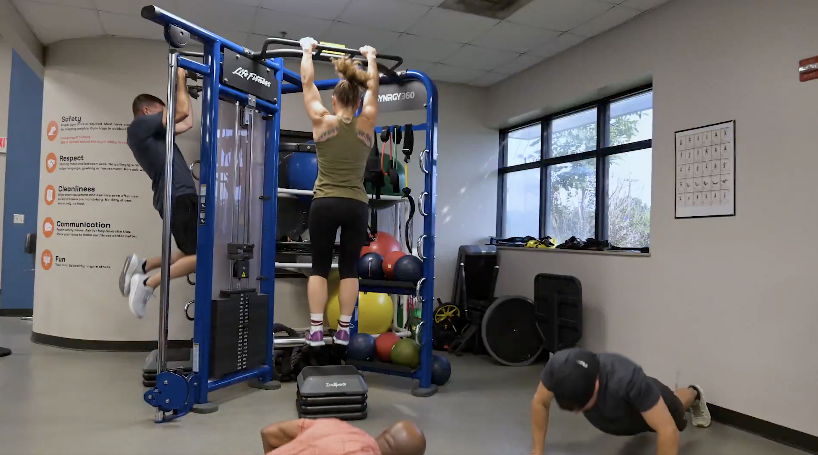 Dos personas entran en el gimnasio cuando dos personas se están estrellando en el frente