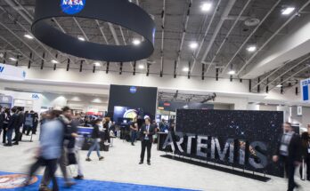 Attendees are seen by the NASA exhibit at the 70th International Astronautical Congress, Friday, Oct. 25, 2019, at the Walter E. Washington Convention Center in Washington.