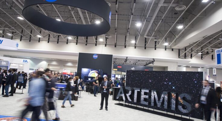 Attendees are seen by the NASA exhibit at the 70th International Astronautical Congress, Friday, Oct. 25, 2019, at the Walter E. Washington Convention Center in Washington.