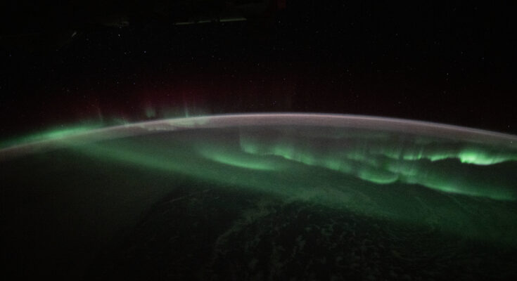 The aurora australis appears to lap over the Earth like a tide washing ashore in this photograph taken at approximately 3:45 a.m. local time from the International Space Station as it orbited 269 miles above the Indian Ocean southwest of Australia.
