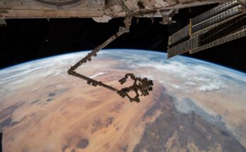 The International Space Station's 57.7-foot-long robotic arm, Canadarm2, with its fine-tuned robotic hand, Dextre, attached is pictured extending from the International Space Station's Harmony module. The orbital outpost was soaring 260 miles above the Saharan Desert in Libya at the time of this photograph.