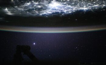 Underneath a starry night sky, the city lights of New Delhi, India, and its surrounding suburbs glitter below Earth's atmospheric glow and at the edge of the Himalayas. This photograph was taken at approximately 2:55 a.m. local time as the International Space Station orbited 260 miles above.