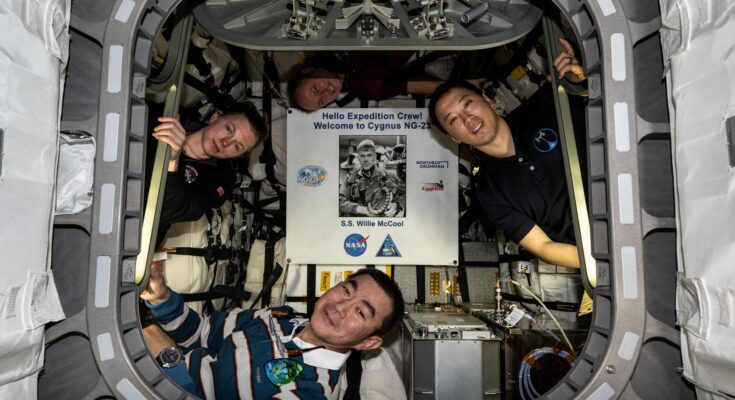 Pictured inside the Northrop Grumman Cygnus XL cargo craft are (clockwise from left) Flight Engineers Zena Cardman, Mike Fincke, and Jonny Kim of NASA, and Flight Engineer Kimiya Yui of JAXA (Japan Aerospace Exploration Agency). Highlighted at center, is a poster of William “Willie” McCool, in honor of the NASA astronaut who perished in 2003 during the space shuttle Columbia accident and for whom the Cygnus spacecraft is named.