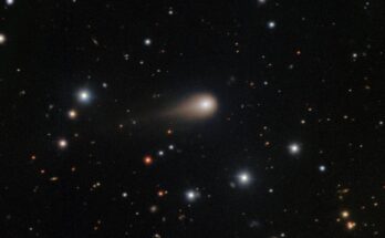 a photo of the comet 3I/ATLAS with its long tail shooting through space