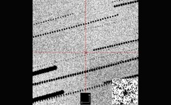 A gray grainy image with a red cross hair in the middle zooming in on a black dot against the grains