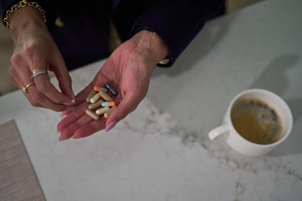 Ruth Wilson toma sus medicamentos recetados y suplementos antes de ir a trabajar. 