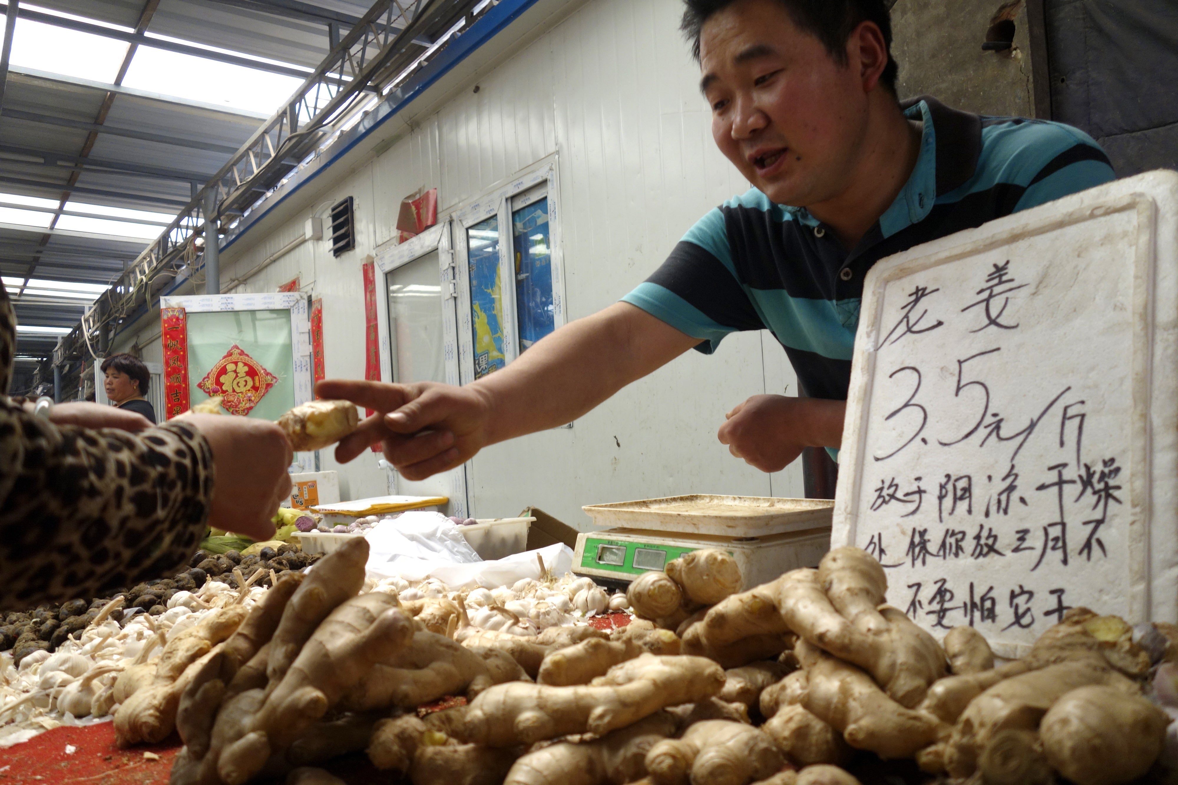 Vandor de China vende raíz de jengibre en el mercado de Beijing. Se sabe que el jengibre ayuda a regular el intestino.