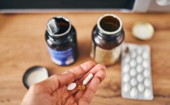 Pouring vitamins on one hand from a bottle