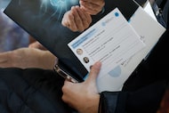 Un asistente sostiene un folleto durante la Conferencia Empoderando a las mujeres a través de la salud cerebral...