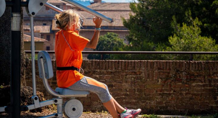 A woman uses outdoor gym equipment